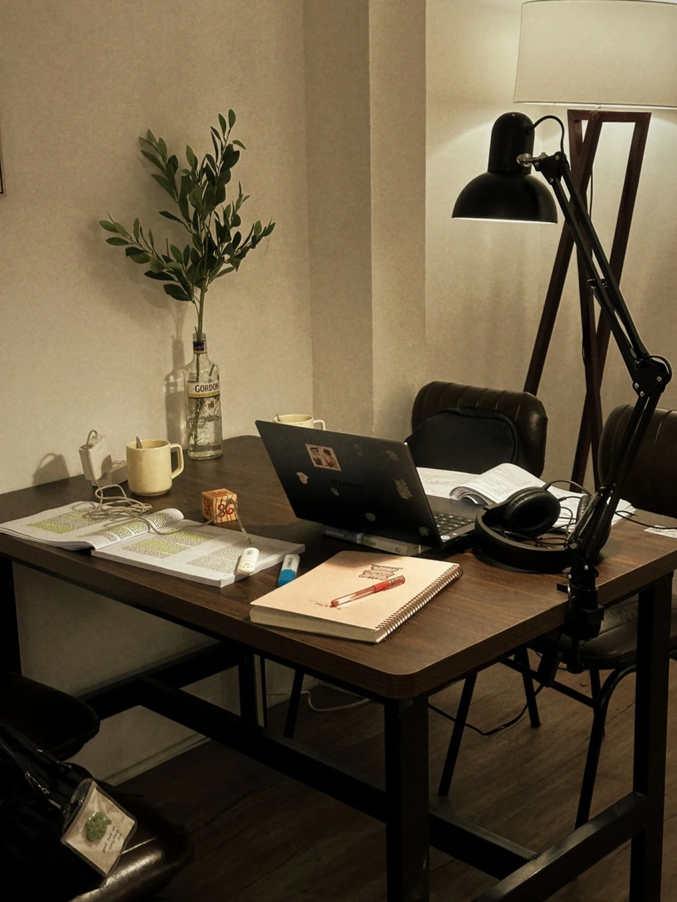 Bàn học có laptop, sách và đèn kẹp